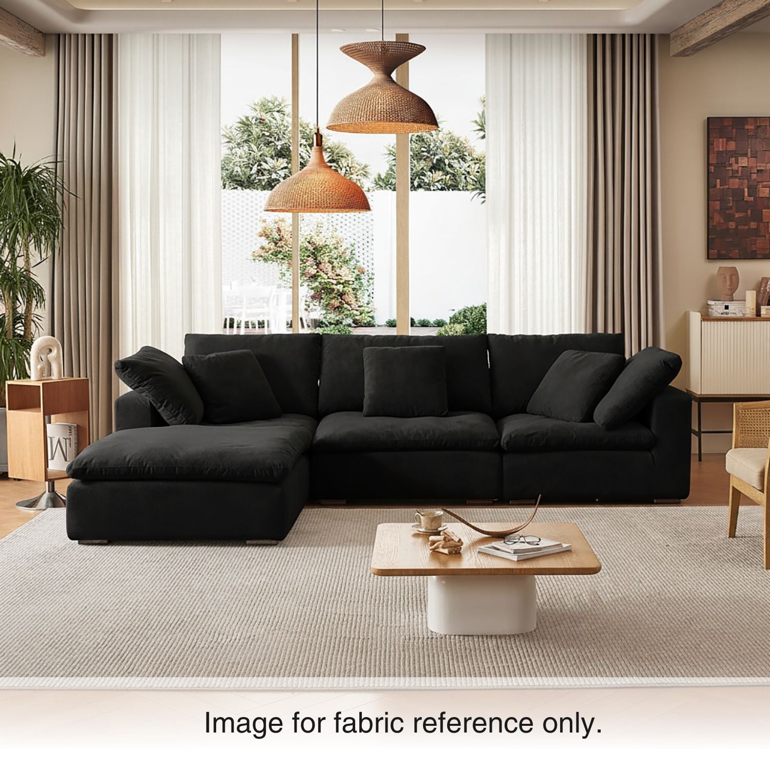 Jet black velvet sectional couch from Mario Capasa in a modern living room with warm lighting