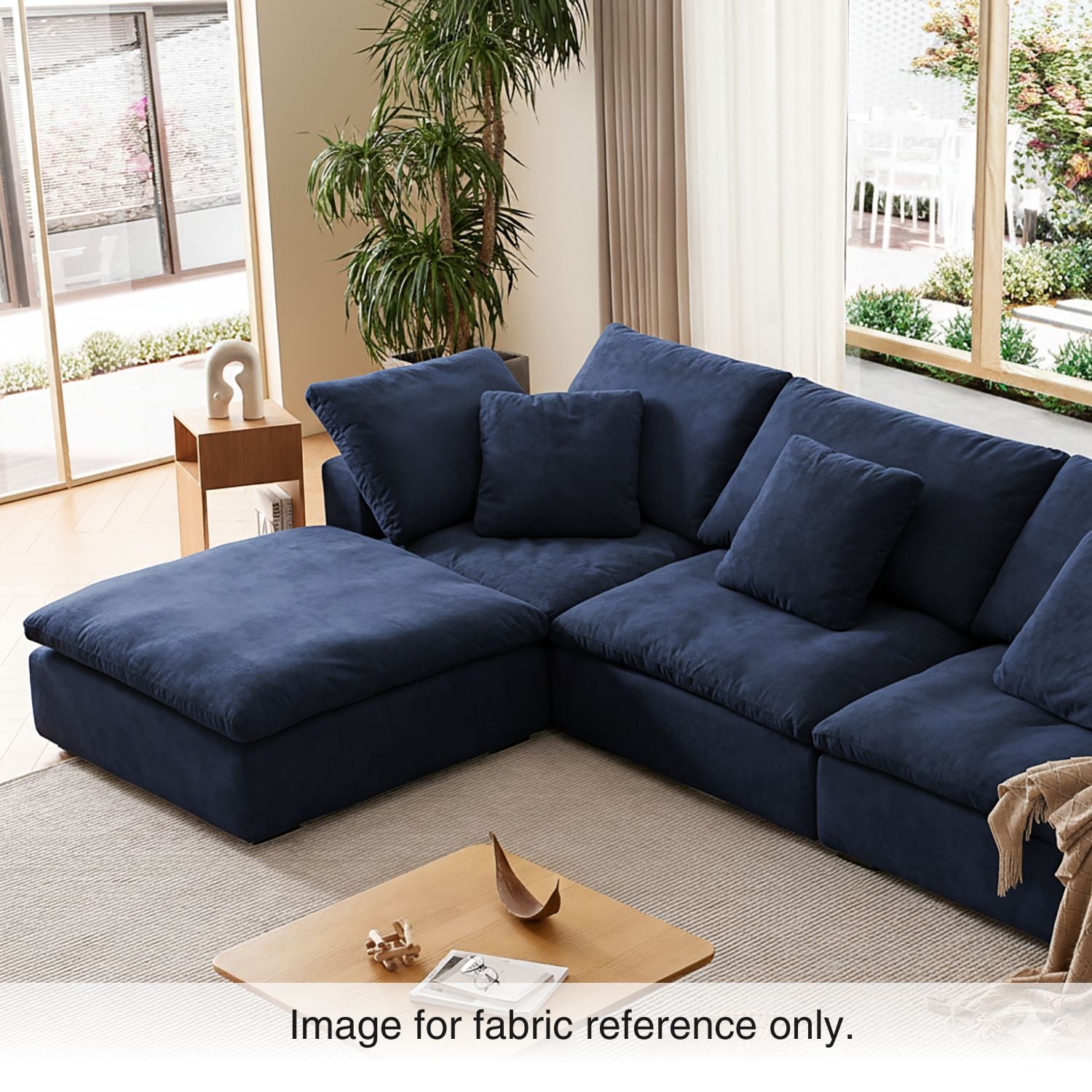 Blue velvet sectional couch with deep seating and plush cushions, styled in a warm living room interior from the Tivoli Velvet Couch Collection by Mario Capasa.