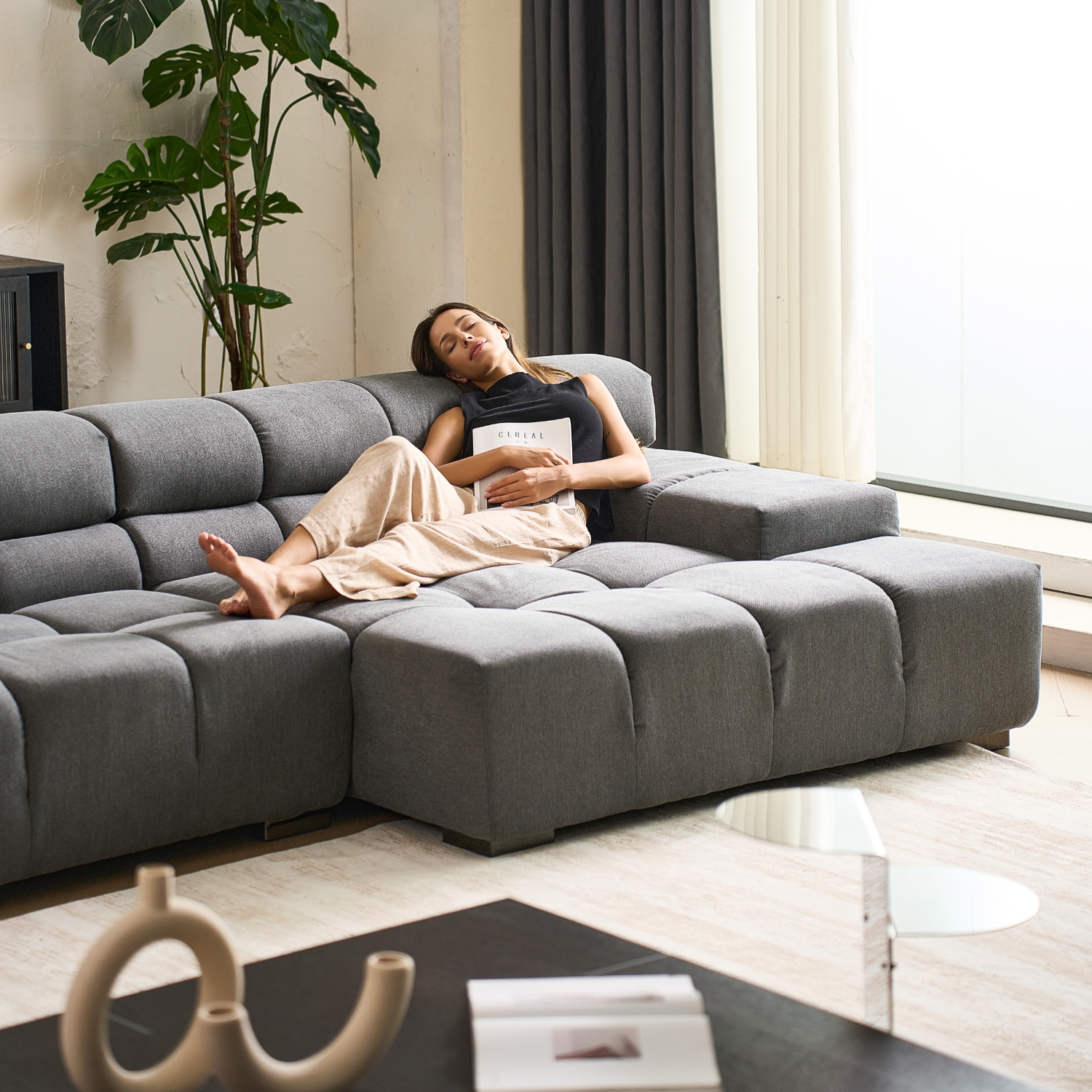 Woman sleeps on Mario Capasa gray modular sectional sofa with chaise