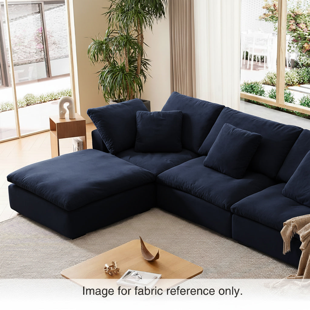 Blue velvet sectional couch with deep seating and plush cushions, styled in a warm living room interior from the Tivoli Velvet Couch Collection by Mario Capasa.