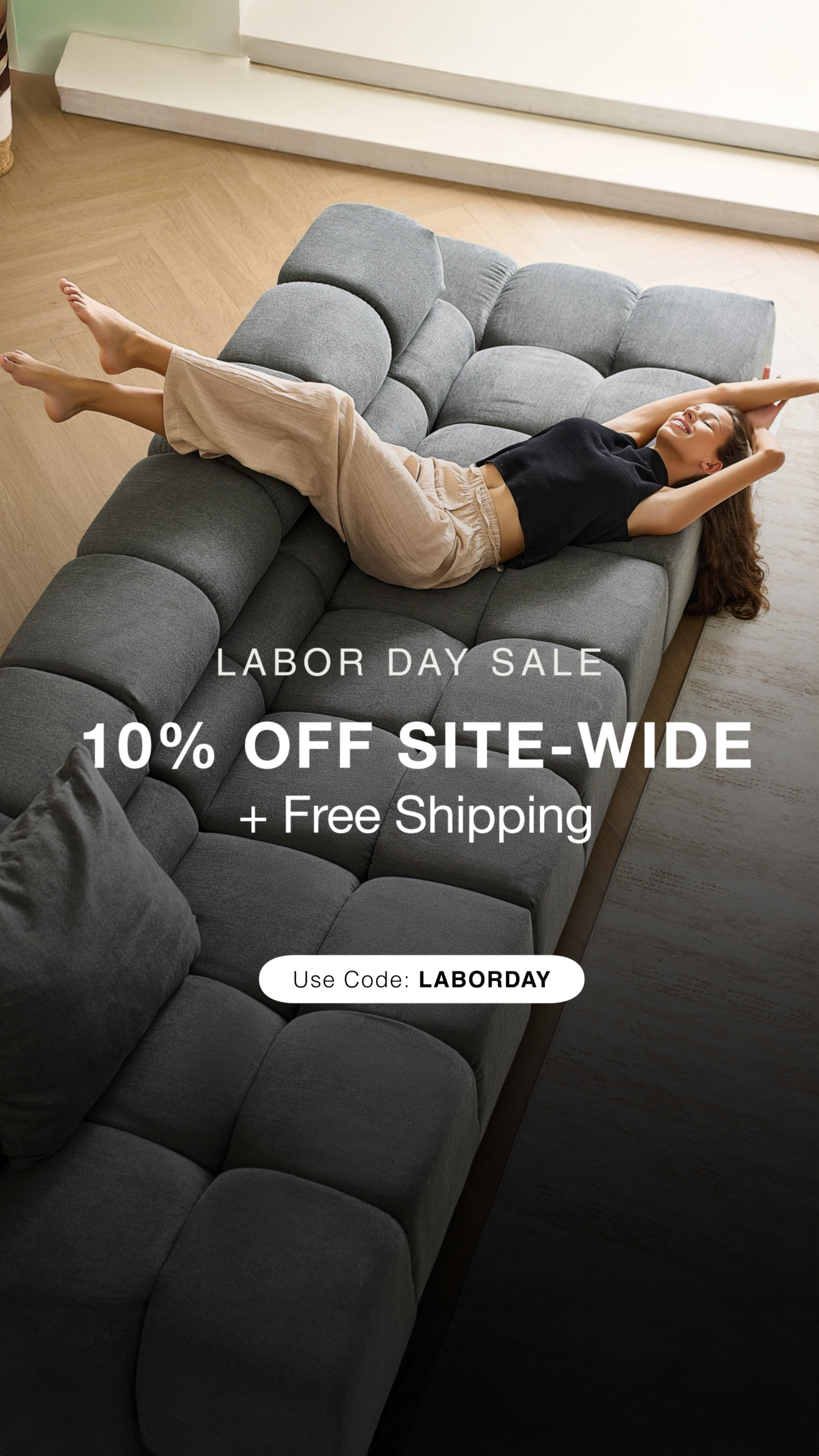 Person lying on a gray sectional sofa with Labor Day sale text overlay.