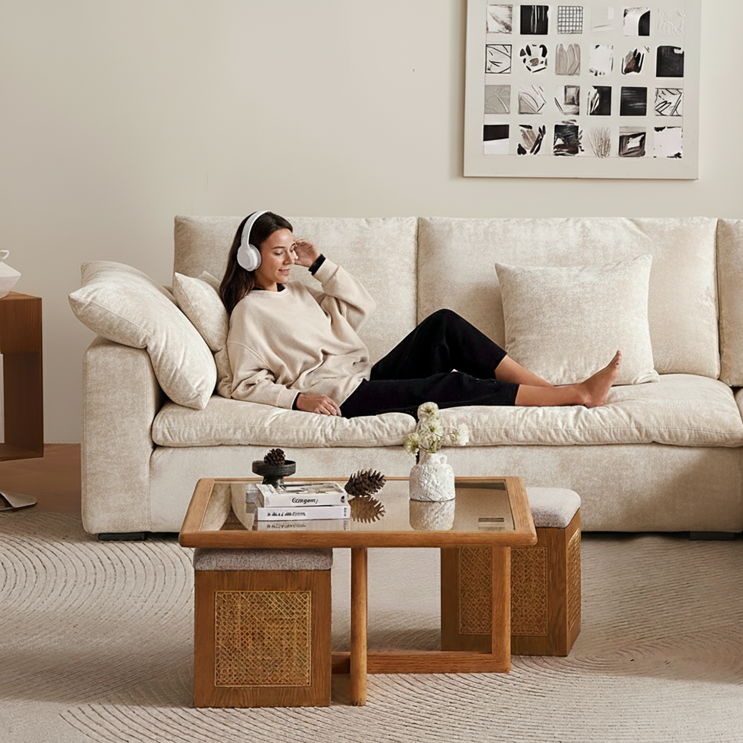 Woman sitting on a beige sofa in a living room with a wooden coffee table.